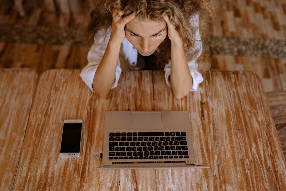 woman sitting in front of her computer, frustrated, wondering "why am i not getting job interviews"